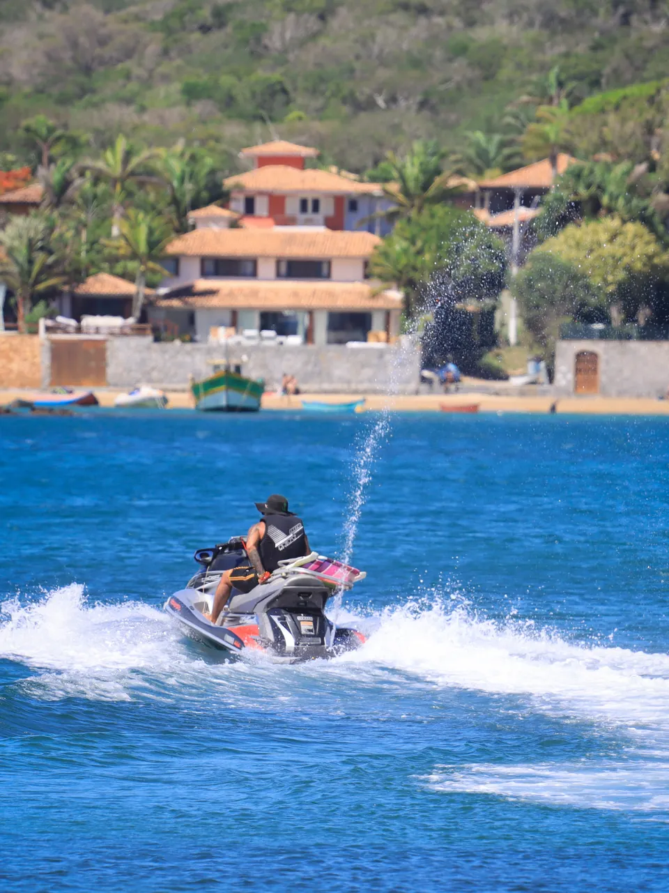 Un viajero conduce una moto acuática sobre agua azul