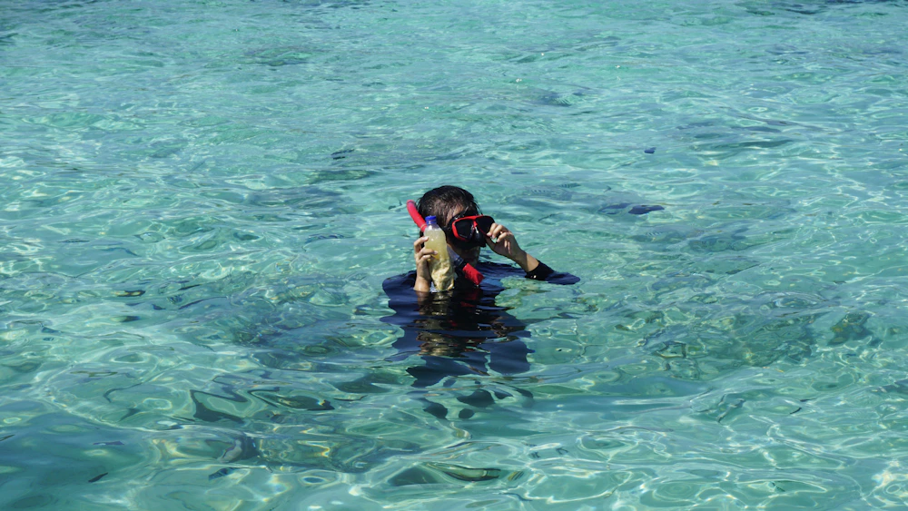 Una persona explora el mar turquesa con máscara de snorkel